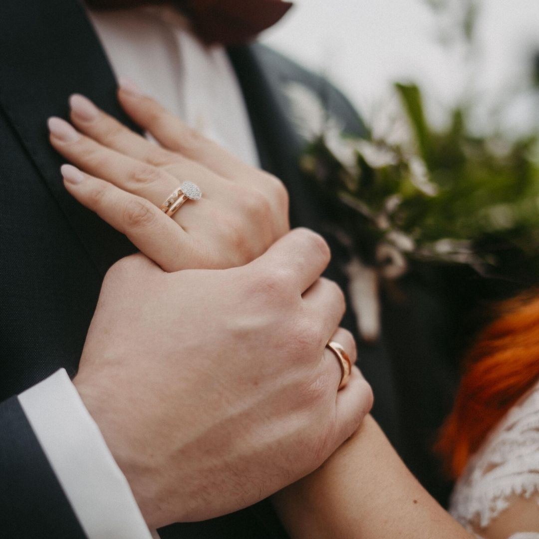 Die Hände des Hochzeitspaares mit ihren Eheringen als Symbol der Liebe.